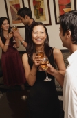 woman smiling in conversation with guy at party (vertical) - Alex Mares-Manton