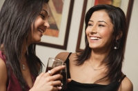 close up of two women talking, drinks in hand - Alex Mares-Manton