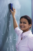 teacher smiling as she erases at chalkboard - Alex Mares-Manton