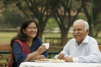 senior couple having coffee outdoors - Manoj Adhikari