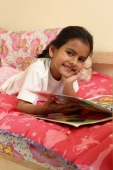 Girl reading book in bed - Deepak Budhraja