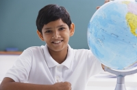 boy smiles at camera with globe - Alex Mares-Manton