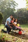 Family on park bench, red ball - Deepak Budhraja