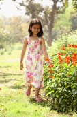 Young girl walking next to flowers - Deepak Budhraja