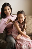 mother and daughter sitting on couch smiling - Alex Mares-Manton