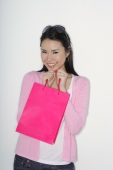 woman holding shopping bag to chin - Yukmin