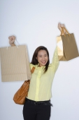 woman holding up shopping bags - Yukmin