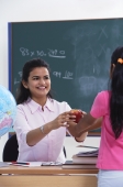 student handing apple to teacher - Alex Mares-Manton