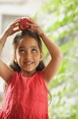little girl holding apple on her head - Alex Mares-Manton