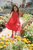 little girl in red dress standing among potted flowers - Alex Mares-Manton