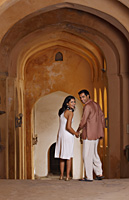 couple walking in arched hallway - Vivek Sharma