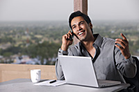 man on phone, working at laptop computer - Vivek Sharma