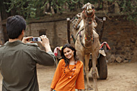man taking photo of woman in front of camel - Vivek Sharma