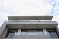 businessman looking over edge of balcony - Alex Mares-Manton