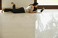 young woman on floor using computer - Alex Mares-Manton