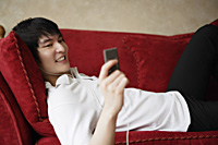 young man laying on sofa, MP3 player - Yukmin