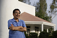 smiling man standing in front of house - Alex Mares-Manton