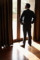 man standing at window - Alex Mares-Manton