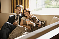 couple on couch holding glasses of wine - Alex Mares-Manton