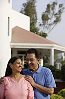 smiling couple standing in front of house - Alex Mares-Manton