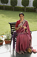 woman wearing a sari, knitting - Alex Mares-Manton