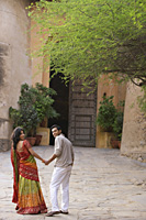 young couple holding hands in courtyard - Alex Mares-Manton