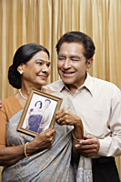 portrait of couple holding photograph - Alex Mares-Manton