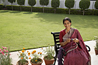 woman wearing a sari, knitting - Alex Mares-Manton