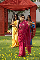 three young women wearing saris, in front of tent - Alex Mares-Manton