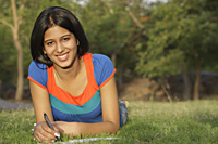 Teen girl writing in notebook, in park - Vivek Sharma