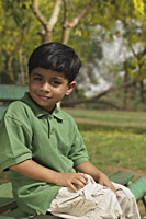 Little boy sitting on park bench - Vivek Sharma