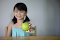 Little girl offering green apple - Yukmin