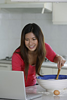 Woman reading recipe on laptop - Yukmin