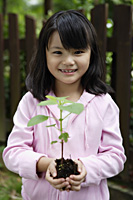 Girl holding plant in soil - Yukmin