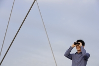 man looking through binoculars - Yukmin