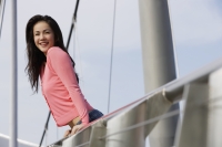 Young woman leaning over bridge - Yukmin