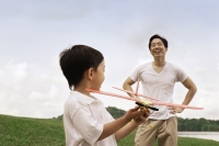 Father watching son play with toy airplane - Yukmin