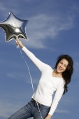 Young woman with silver star-shaped balloon - Yukmin