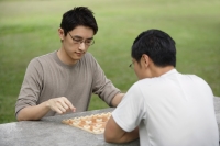 Two men playing Chinese chess in park - Yukmin