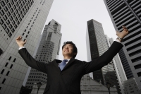 Businessman raising arms in air - Yukmin