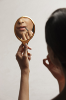 hand of woman holding up mirror with reflection - Vivek Sharma
