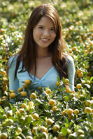 Young woman among orange plants - Nugene Chiang