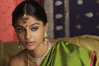 woman wearing sari, surrounded by sari fabric, decorated with henna tattoos, jewelry and bindi - Vivek Sharma