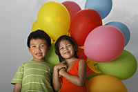 Boy and girl holding balloons. - Yukmin