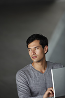 man working on laptop, looking away - Yukmin