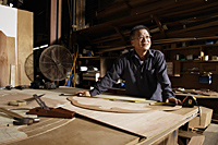 Mature man working in his wood shop. - Nugene Chiang