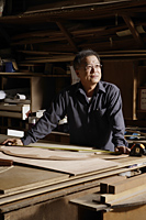 Mature man working with wood. - Nugene Chiang