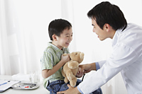 Doctor laughing with young boy - Yukmin