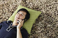 Young man lying on floor talking on phone - Yukmin