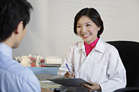 Woman doctor looking at patient and smiling - Yukmin